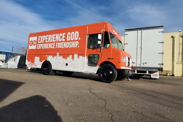 Delivery truck with custom orange vehicle wrap